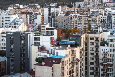 Canlı bir şehir silueti, şehir manzarasını aydınlatan sıcak ışıkla modern binaların karışımıyla dolu..
