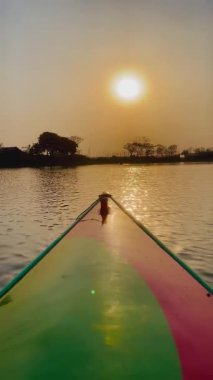 Gün batımında tekne, nehirde güzel mutlu bir kano. Gün batımında nehirde kanoyla kürek çekmek..