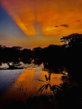 Denizin üzerinde gün batımı, Durgun Su Üzerinde Günbatımı Yansımaları Dramatik Gökyüzü ve Güneş Işığı.