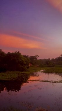 Nehrin üzerinde gün batımı, nehirde günbatımı yansıması, nehrin yanındaki köy güneşin yansımasından dolayı çok güzel görünüyor..