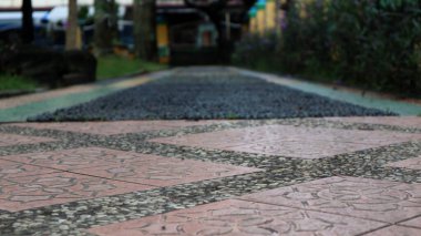 Geçit kırmızı fayanslarla döşenmiştir. Karmaşık çiçek desenleriyle süslenmiştir. Küçük, karanlık çakıl taşlarıyla çevrelenmiştir..