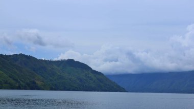 Danau Toba, 09 Kasım 2024, Endonezya 'nın başkenti Sumatra Utara' da yemyeşil dağlarla çevrili sakin bir göle uzanır..