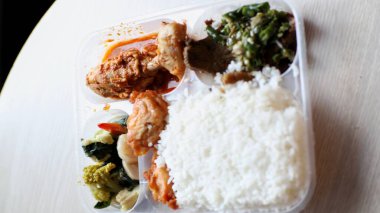 Görüntü tipik bir Endonezya yemeğini plastik bir kabın içinde gösteriyor..