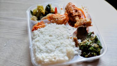 Görüntü tipik bir Endonezya yemeğini plastik bir kabın içinde gösteriyor..