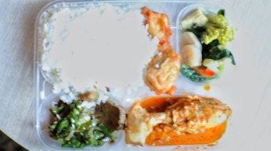 Görüntü tipik bir Endonezya yemeğini plastik bir kabın içinde gösteriyor..