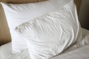 İki beyaz yastık bir yatağa konur..