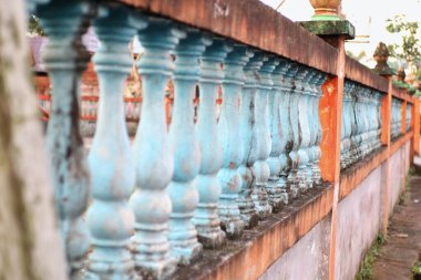 Çit duvarı bir dizi mavi ve beyaz beton balyalarla süslenmiş..