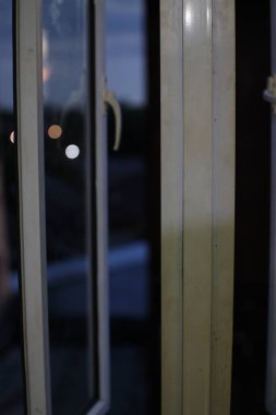 Leke ve çiziklerle dolu kirli, eski bir pencere çerçevesinin yakın çekimi. Cam biraz sisli, dışarıyı göremiyoruz..