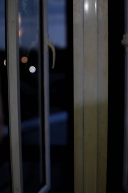 Leke ve çiziklerle dolu kirli, eski bir pencere çerçevesinin yakın çekimi. Cam biraz sisli, dışarıyı göremiyoruz..