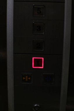 Asansör kontrol panelinin birinci kat düğmesi kırmızıyla aydınlatılmış yakın çekimi..