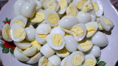 A close-up captures a serving of halved hard-boiled eggs. clipart