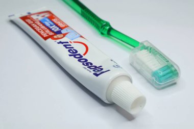 Rantau Kopar, 12-22-2024: Bir tüp Pepsodent diş macunu ve bir diş fırçası beyaz arka planda gösteriliyor. Riau, Endonezya.