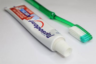 Rantau Kopar, 12-22-2024: Bir tüp Pepsodent diş macunu ve bir diş fırçası beyaz arka planda gösteriliyor. Riau, Endonezya.