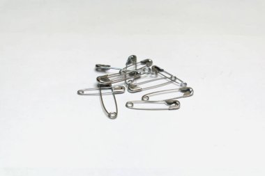 Birkaç çengelli iğne beyaz bir yüzeye saçılmış..