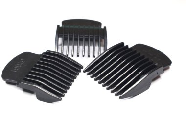 Değişen uzunluktaki birkaç saç kırpıcı beyaz bir yüzeye yerleştirilmiştir..