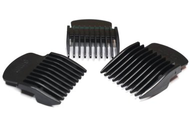 Değişen uzunluktaki birkaç saç kırpıcı beyaz bir yüzeye yerleştirilmiştir..