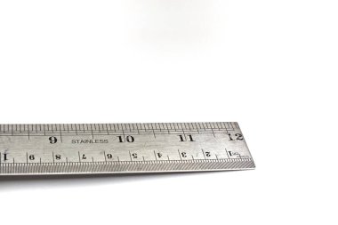 Paslanmaz çelik bir cetvel beyaz bir arkaplanda gösterilir.