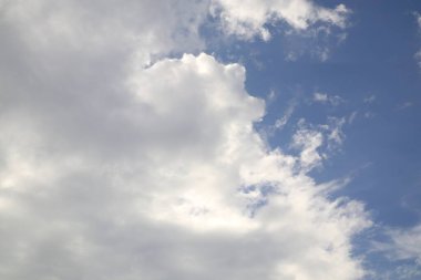 Gökyüzünün büyüleyici bir görüntüsü, mavi bir zemine karşı beyaz ve gri bulutların karışımını sergiliyor. Sahne, bulutların geniş gökyüzüne derinlik ve boyut eklemesiyle huzur ve sükunet hissi uyandırıyor..