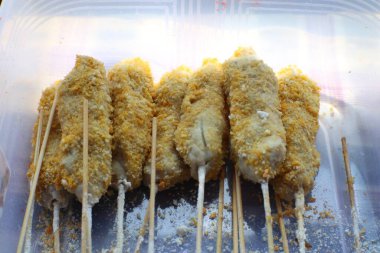 Ekmekli tavuk şiş yakın çekim, hazır ve kızarmaya hazır. Altın-kahverengi kabuklu, çıtır çıtır, lezzetli bir deneyim vaat ediyor..