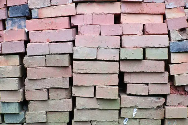 Bir yığın yıpranmış kırmızı tuğlaya yakın çekim. Değişen tonlar ve dokular kırsal ve endüstriyel bir hava yaratıyor. Arkaplan ya da tasarım ögeleri için ideal.