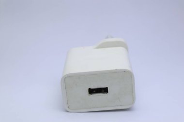 Düz bir arkaplanda beyaz bir USB duvar şarj cihazı bulundu..