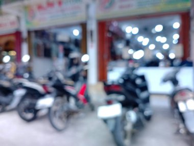 Bulanık görüntü bir dükkanın önüne park etmiş motosikletleri gösteriyor, soyut bir fotoğraf..