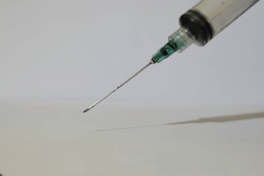 Detaylı bir yakın çekim, temiz bir yüzey üzerinde özenle hazırlanmış bir şırınganın iğnesini ortaya çıkarır.