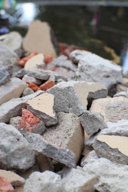 Kırık beton ve tuğla moloz yığınının yakın çekim görüntüsü. İnşaat ve yıkım enkazı, malzeme atıkları.
