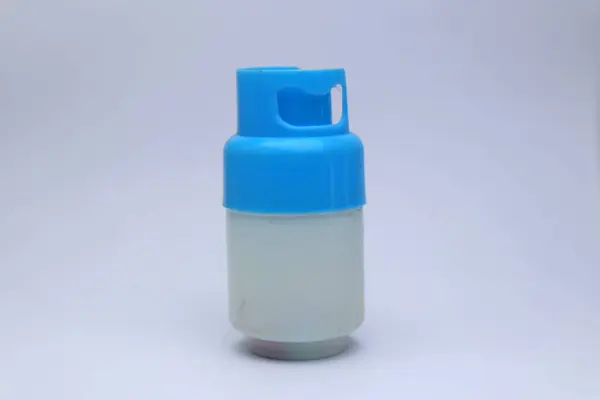 Minyatür, oyuncak gibi bir propan benzin deposu, parlak mavi kapaklı, sade beyaz arka planda..