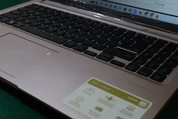 Bir ASUS dizüstü bilgisayarının gül sarısı klavyesi ve dokunmatik ekranının ayrıntılı bir görüntüsü..