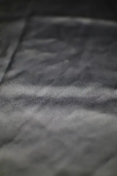 Yakın çekimde çeşitli yaratıcı uygulamalar için yumuşak ve lüks bir zemin sağlayan kömür renkli kadifenin narin dokusu sergileniyor..