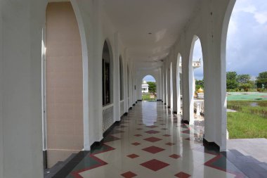 Geometrik fayanslı güneş ışığıyla aydınlatılmış bir sütun, barışçıl ve yansıtıcı bir atmosfer yaratır. Yapının temiz hatları ve sakin atmosferi çarpıcı..