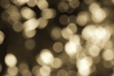 Soyut altın bokeh ışıkları rüya gibi bir atmosfer yaratır. Bulanık ışıklar altın renginde parıldıyor, klasik bir stil ve yumuşak, parlak bir etki yaratıyor..