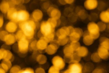 Soyut altın bokeh ışıkları bulanık bir arkaplan ile harmanlanır. Yumuşak ve rüya gibi atmosfer bir merak ve şenlik lüksünü çağrıştırıyor.. 
