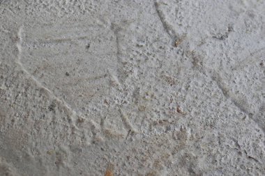 Bu, pürüzlü gri beton bir yüzeyin yakın plan görüntüsü. Kumlu ve sert efektli yüzey arka plan veya kaplama materyali için uygundur.