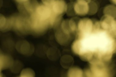 Bokeh ışıklarının altın sarısı ve koyu tonlarda olduğu odaklanmış bir görüntü. Soyut desen rüya gibi ve ruhani bir etki yaratıyor..