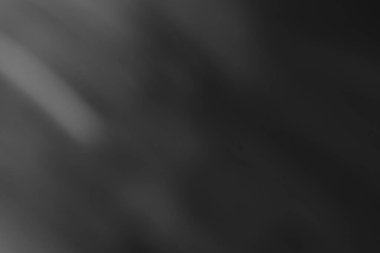 Hafif ışık çizgileri içeren siyah ve beyaz bir minimalist arka planı bulanıklaştırdı. Tasarım projelerinize veya sunumlarınıza derinlik ve doku eklemek için mükemmel.