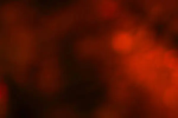 Koyu kırmızı ve turuncu bokeh etkisine sahip bulanık bir arka plan, pürüzsüz, parıldayan ışıklarıyla sıcak ve neşeli bir atmosfer yaratıyor..