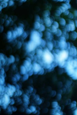 Soyut mavi bokeh arkaplanı. Odaklanamayan mavi ışıklar. Yumuşak bokeh ışıkları olan bulanık bir arka plan. Bokeh efektli soyut bir arka plan. Mevsimlik tatiller, festivaller ya da yaratıcı projeler için mükemmel..