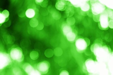 Büyüleyici soyut bir tasarım parlak, yeşil bir bokeh arkaplan, canlı dairesel ışıklar, doğanın sakin güzelliğini sembolize eden.