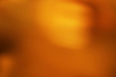 Yumuşak, bulanık dokusu olan soyut kehribar eğimli arkaplan. Sıcak renk şemasına sahip modern tasarım ve yaratıcı projeler için ideal.