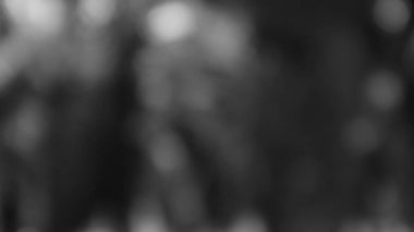 Gri tonlu bir Bokeh soyutu, karanlık bir arkaplana karşı yumuşak, odak dışı ışık küreleri. Basit ve zarif bir element, ince bir arkaplan için mükemmel..