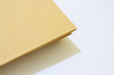 Modern görünüş için temiz beyaz arkaplanı ve yumuşak ışıklandırması olan kahverengi kağıtlı minimalist bir yakın çekim..