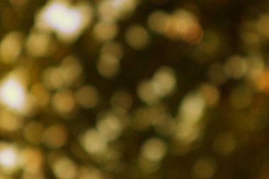 Altın bokeh ışıkları loş ışıklandırma arkaplanından süzülerek yumuşak ve büyüleyici bir ruhani atmosfer yaratıyor..