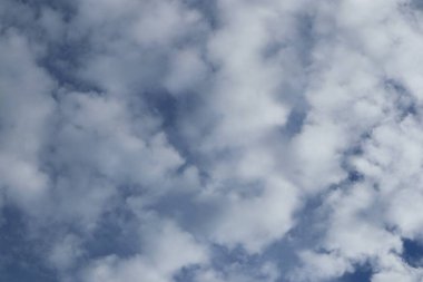 Mavi gökyüzüne dağılmış bulutlar sakin ve havadar bir atmosfer yaratır.