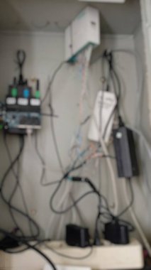 Karışık kablolar ve cihazlarla karışık elektrik paneli, kaotik ağ altyapısını gösteriyor