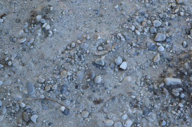 Kapalı kaplama desenli zemin, çeşitli gri tonlara sahip küçük çakıl ve kum içeriyor..