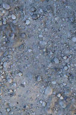 Yakından çekilen, kurumuş bir nehir yatağı dokusu, kumlu kumlarla çakıl taşlarının karışımını sergiliyor..