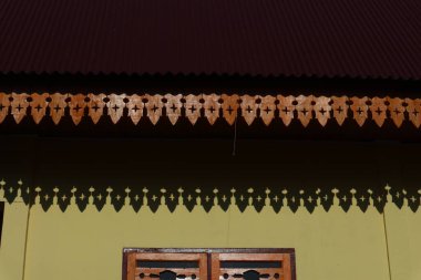 Geleneksel mimari karmaşık ahşap oyma detayları ve zengin gölgeler sergiliyor.