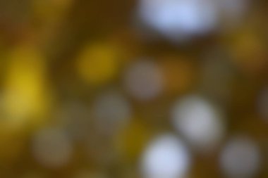 Yumuşak bulanık arkaplan, altın ışıklı bokeh daireler, sıcak kahverengi tonlar ve tasarım projeleri için uygun nazik bir dokuya sahip soyut desen oluşturur..